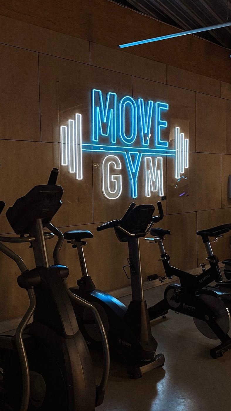Blå LED-neonskylt med gymlogotyp på träpanel